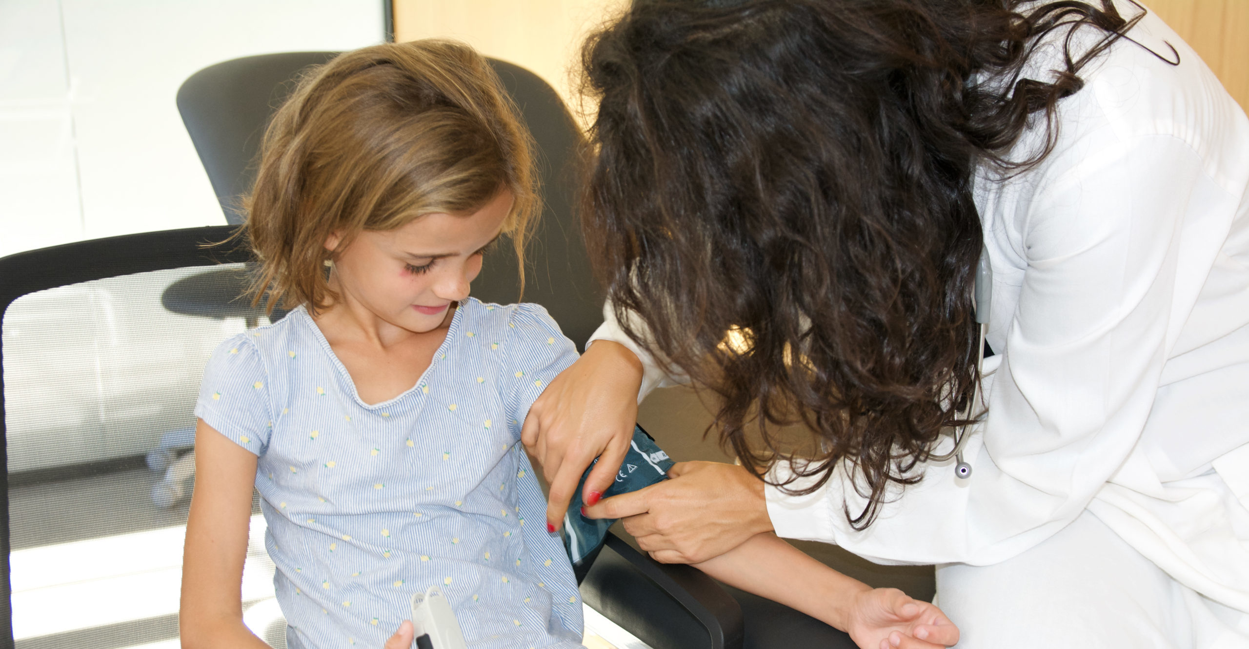 médecin qui prend la tension d'une enfant