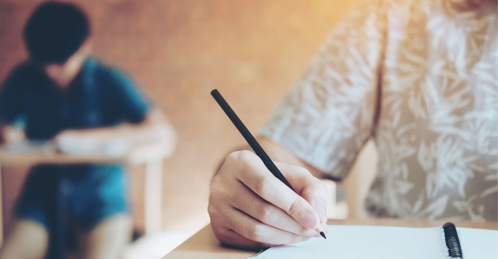 une fille qui écrit sur un cahier