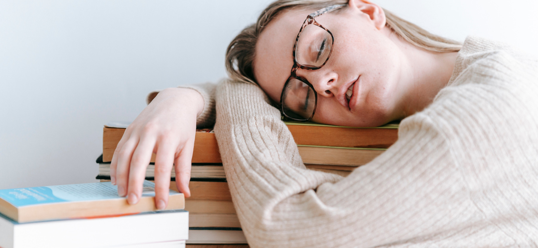 jeune femme endormie sur une pile de livre